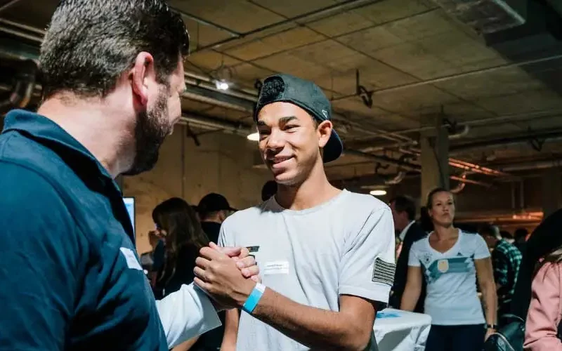 Ein junger Bewerber begrüßt einen Unternehmensvertreter beim Karriere Kick – persönliche Begegnung zur Lehrlingsgewinnung